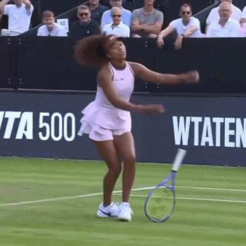 A Woman Is Holding A Tennis Racquet On A Tennis Court In Front Of A Banner That Says Wta 500 GIF