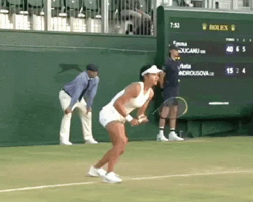 A Woman Is Holding A Tennis Racquet On A Tennis Court In Front Of A Scoreboard That Says Rolex On It GIF