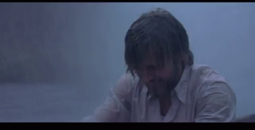 A Woman Is Holding A White Cloth Over Her Head In The Rain . GIF