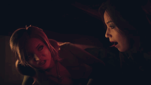 A Woman Is Holding Another Woman 'S Hand While They Look At Something In A Dark Room GIF