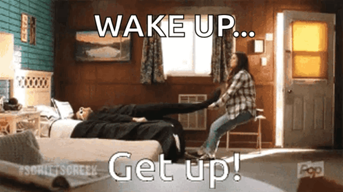 a woman is holding another woman 's leg in a room with the words wake up get up written on the bottom
