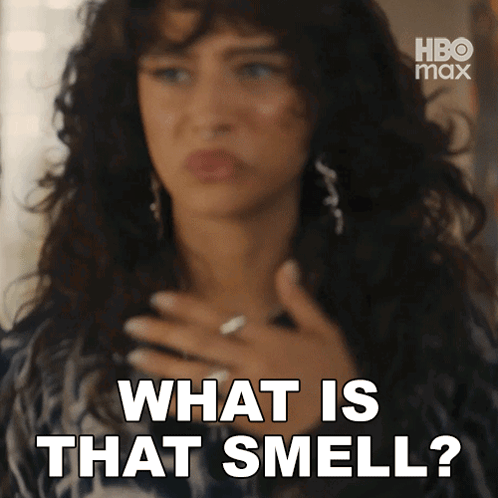 A Woman Is Holding Her Chest And Saying What Is That Smell GIF