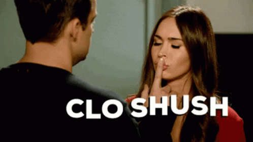 A Woman Is Holding Her Finger To Her Lips While A Man Looks On And The Words Clo Shush Are Above Her GIF