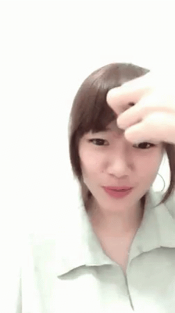 A Woman Is Holding Her Hair Up In A Ponytail . GIF