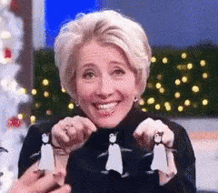 A Woman Is Holding Three Penguins In Her Hands GIF