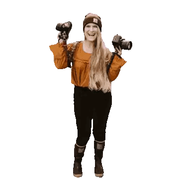 a woman is holding two cameras and smiling