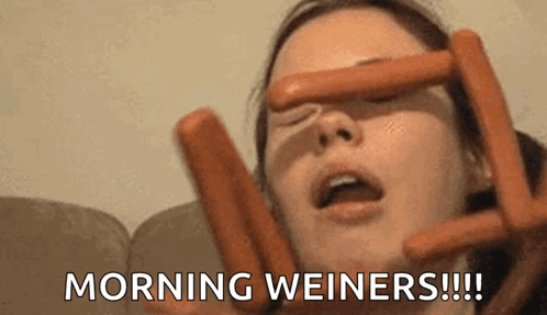 A Woman Is Holding Two Hot Dogs In Front Of Her Face And Says Morning Weiners GIF