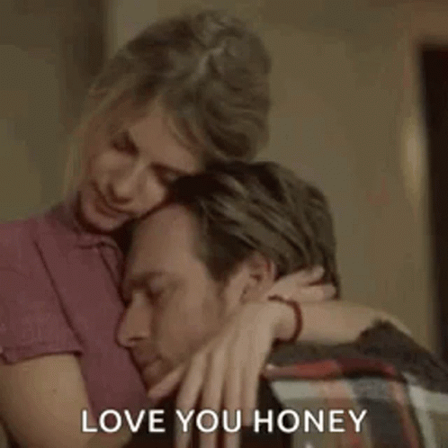 a woman is hugging a man with the words `` love you honey '' written on it .