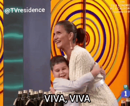 A Woman Is Hugging A Young Boy With The Words Viva Viva Written On The Bottom GIF