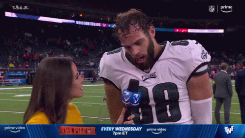 a woman is interviewing a football player wearing a number 38 jersey
