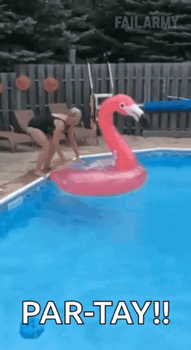 A Woman Is Jumping Into A Swimming Pool With A Flamingo Float . GIF