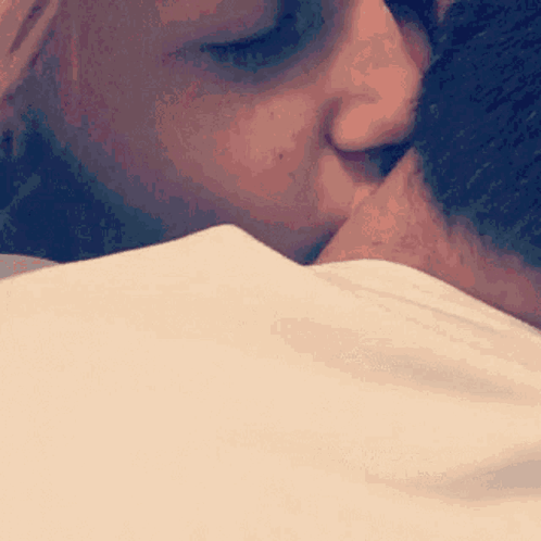 A Woman Is Kissing A Man On The Forehead GIF