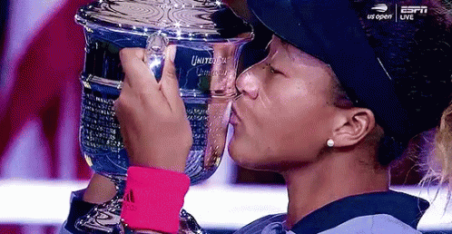 A Woman Is Kissing A Trophy That Says Us Open On It GIF