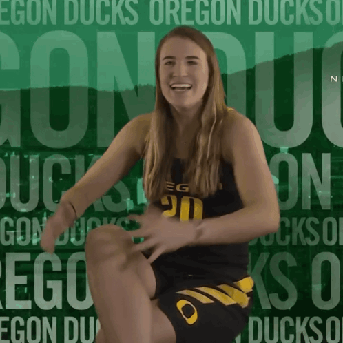 A Woman Is Kneeling Down In Front Of A Green Background That Says Egon Ducks On It GIF
