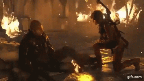 A Woman Is Kneeling Down Next To A Man In A Video Game . GIF