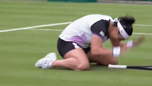 A Woman Is Kneeling Down On A Tennis Court With Her Head On A Tennis Racquet GIF