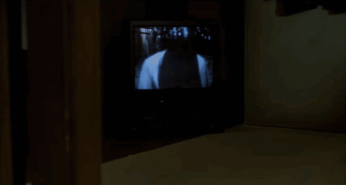 A Woman Is Kneeling On The Floor In Front Of A Tv Screen GIF