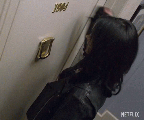 a woman is knocking on a door that has the number 1904 on it