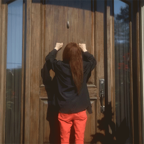 a woman is knocking on a door with her fist