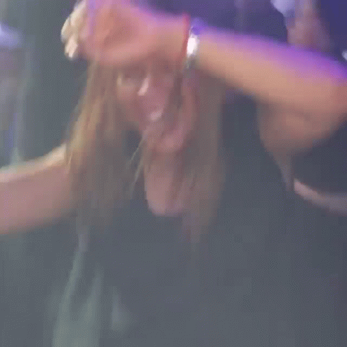 A Woman Is Laughing And Covering Her Ears In A Blurry Photo GIF
