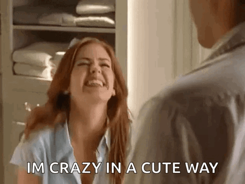 A Woman Is Laughing And Talking To A Man In A Room . GIF