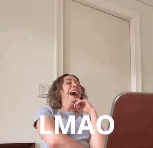 A Woman Is Laughing In Front Of A Laptop With The Word Lmao Written On Her Face GIF