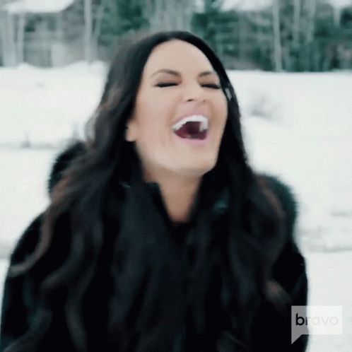 A Woman Is Laughing In The Snow With Bravo On The Bottom GIF