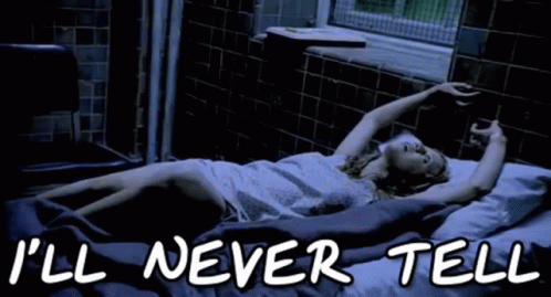 A Woman Is Laying In A Bed With The Words " I 'Ll Never Tell " On The Bottom GIF