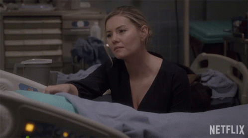 a woman is laying in a hospital bed with a netflix logo behind her