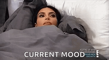 A Woman Is Laying In Bed Under A Blanket With The Words `` Current Mood '' Written On The Bottom . GIF