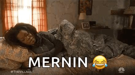 A Woman Is Laying In Bed With A Smiley Face And The Words Mernin Written On It . GIF