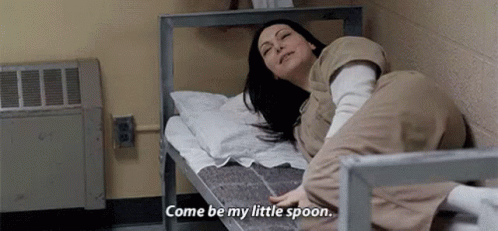 A Woman Is Laying On A Bed In A Prison Cell And Says `` Come Be My Little Spoon '' . GIF
