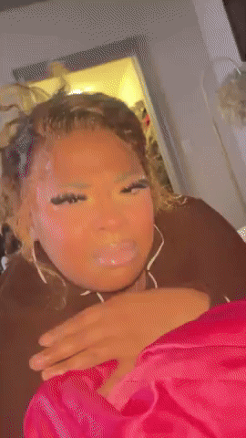 A Woman Is Laying On A Bed With Her Eyes Closed And Making A Funny Face . GIF