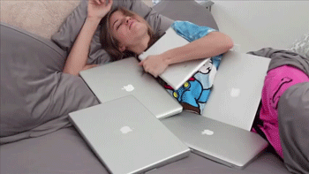 A Woman Is Laying On A Bed With Many Apple Laptops GIF