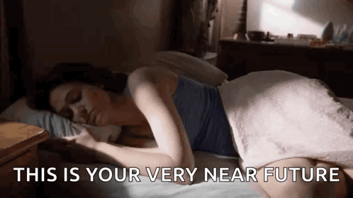 A Woman Is Laying On A Bed With The Words `` This Is Your Very Near Future '' Written On The Bottom . GIF