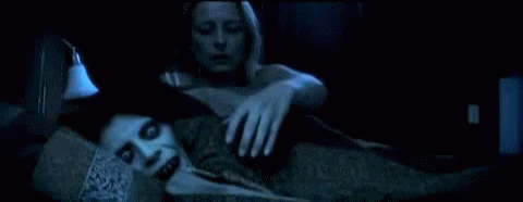 A Woman Is Laying On A Couch With A Ghostly Figure Behind Her GIF