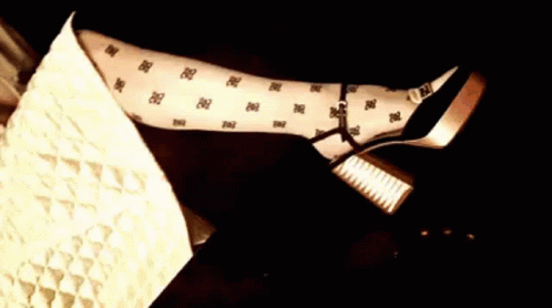 A Woman Is Laying On A Couch With Her Legs Crossed And Wearing Polka Dot Tights . GIF