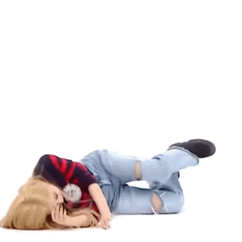 A Woman Is Laying On Her Stomach On The Floor With Her Legs Crossed . GIF
