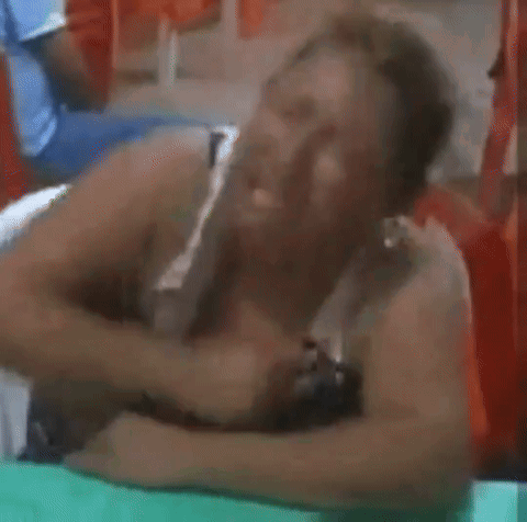 A Woman Is Laying On Her Stomach With Her Head On A Table . GIF