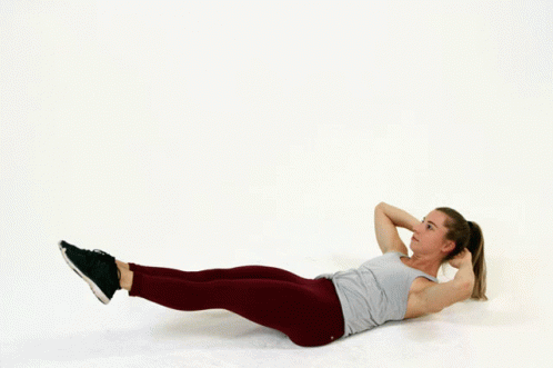 A Woman Is Laying On The Floor Doing A Crunch Exercise GIF