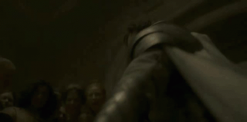 A Woman Is Laying On The Ground With A Knife In Her Hand And A Light Shining On Her Face . GIF