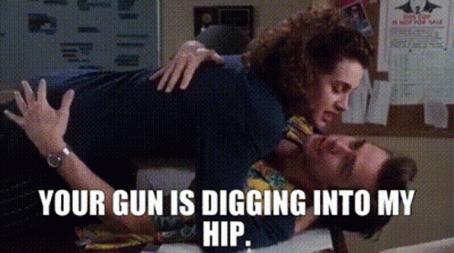 A Woman Is Laying On Top Of A Man With The Words `` Your Gun Is Digging Into My Hip '' . GIF