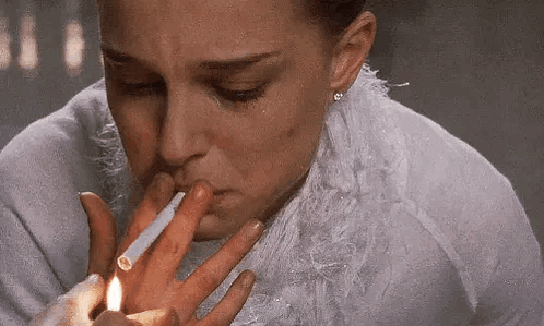 A Woman Is Lighting A Cigarette With A Lighter . GIF