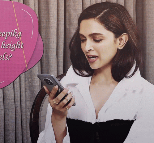 A Woman Is Looking At Her Phone With A Pink Speech Bubble That Says ' Deepika Height Els ' GIF
