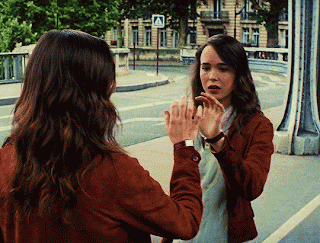 A Woman Is Looking At Herself In A Mirror GIF