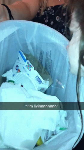 A Woman Is Looking Into A Trash Can And Says " I 'M Livinnnnn " GIF