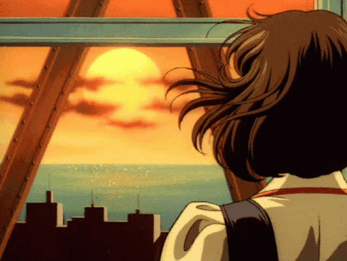 A Woman Is Looking Out A Window At The Sun Setting Over The Ocean GIF