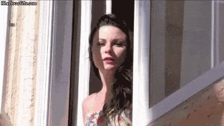 A Woman Is Looking Out Of A Window With Hilariousgifs.com Written On The Bottom GIF