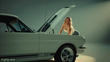 a woman is looking under the hood of a gt 350