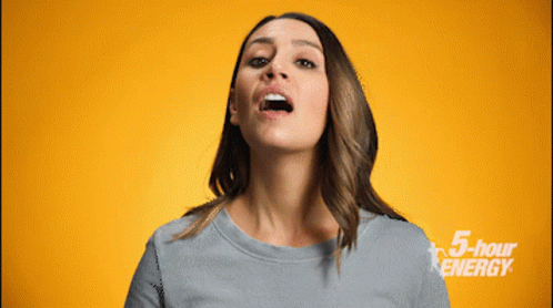 A Woman Is Making A Face In Front Of A Yellow Background With 5 Hour Energy Written On It GIF